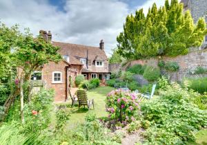 a garden in front of a house with flowers at Church Cottage in Barham