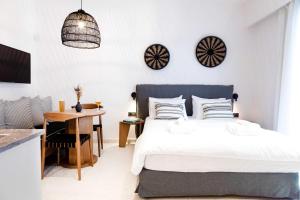 Schlafzimmer mit einem Bett, einem Schreibtisch und einem Tisch in der Unterkunft ELMARAL living experience "Adults Only" in Agia Pelagia