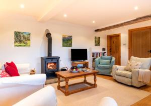 a living room with a fireplace and a tv at Dairy Cottage in Wadhurst