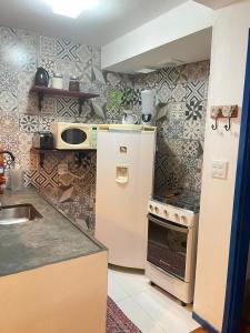 a kitchen with a white refrigerator and a stove at Casa charmosa no Centro Histórico com garagem in Ouro Preto