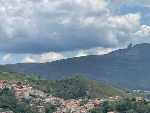 a town on a hill with mountains in the background at Casa charmosa no Centro Histórico com garagem in Ouro Preto