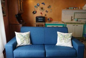 een blauwe bank met twee vlinderkussens erop bij Casa Elsa Terrazza con vista by ItalianHost in Maiori +10 foto's