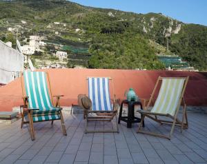 twee stoelen en een tafel op een dak bij Casa Elsa Terrazza con vista by ItalianHost in Maiori