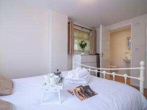 um quarto branco com uma cama branca e um frigorífico em Pass the Keys Beautiful apartment with stunning views em Worcester