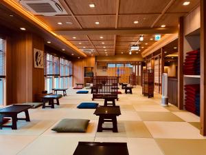 a lobby with tables and benches in a building at かぷせる旅籠 赤坂 SPABLIC INN in Tokyo