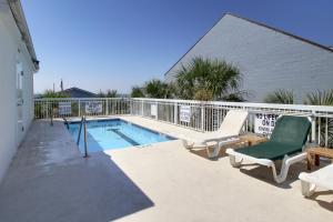 a swimming pool with two lounge chairs next to a building at Seaside Inn - Isle of Palms in Isle of Palms