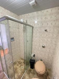 a bathroom with a toilet and a glass shower at Casa charmosa no Centro Histórico com garagem in Ouro Preto
