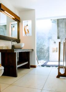 ein Bad mit einem Waschbecken und einem Spiegel in der Unterkunft Island View Bar & Bungalow in Gili Air