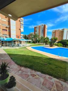 a swimming pool in a park with tall buildings at Apartamento Costa de Poniente in Benidorm