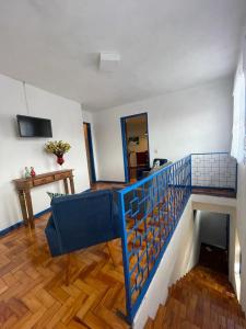 a living room with a blue railing and a staircase at Casa charmosa no Centro Histórico com garagem in Ouro Preto