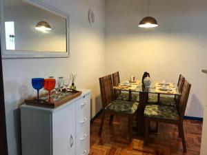 a dining room with a table and chairs with wine glasses at Casa charmosa no Centro Histórico com garagem in Ouro Preto