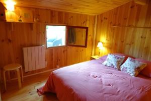 a bedroom with a bed in a wooden room at LE COULOUMAT Saucats in Saucats