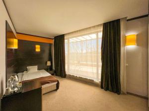 1 dormitorio con cama y ventana grande en Hotel Dream, en Sofía