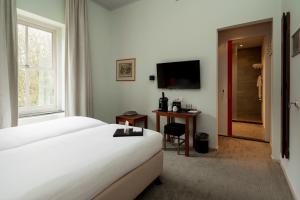 una camera d'albergo con letto e TV di Leerhotel Het Klooster ad Amersfoort