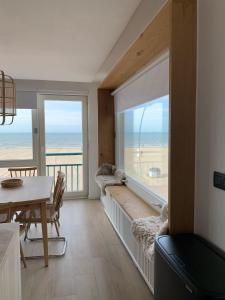 Les pieds dans le sable في دي بان: غرفة معيشة مع نافذة كبيرة مطلة على الشاطئ