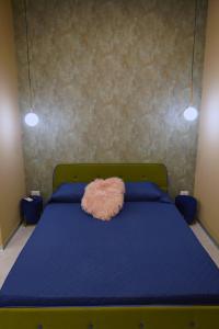 ein Schlafzimmer mit einem blauen Bett und einem rosa Kissen darauf in der Unterkunft Marchese 124 in Bari