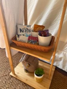 una estantería de madera con una cesta de comida. en Between Rivers Camping @ The Old George Inn, en Sykehouse