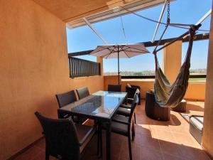 uma sala de jantar com uma rede de descanso, uma mesa e cadeiras em Casa Léa em Torre-Pacheco