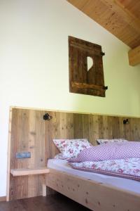 a bedroom with a bed with a wooden wall at Ferienhaus Schwab in Mittersill
