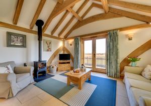 a living room with a couch and a wood stove at Glebe Cottage in Stone