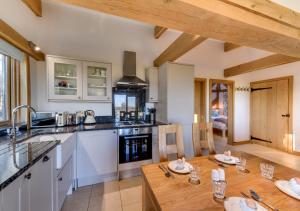 a kitchen with a wooden table and a counter top at Glebe Cottage in Stone