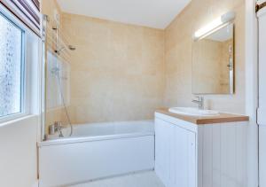 a bathroom with a tub and a sink and a bath tubermott at Goodwin Cottage in Broadstairs