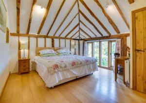 a bedroom with a bed in a room with wooden ceilings at Hartley Dyke Barn in Cranbrook