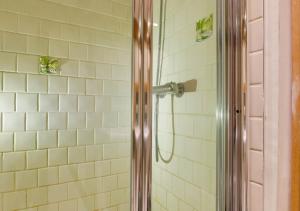a shower in a bathroom with white tiles at Hartley Dyke Barn in Cranbrook