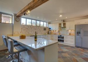 a kitchen with a large island with a bottle of wine at Hawkridge Oast in Sissinghurst