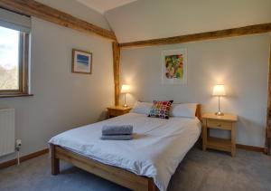 1 dormitorio con 1 cama con 2 mesas y 2 lámparas en Hawkridge Oast, en Sissinghurst