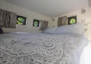 1 Schlafzimmer mit einem weißen Bett und 2 Fenstern in der Unterkunft Hattie the Horse Box in Hawkhurst