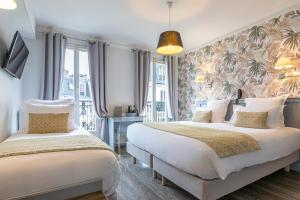 una camera con due letti e una parete di tende di Hotel Splendid a Parigi