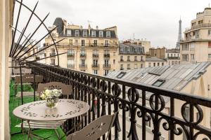 a table and chairs on a balcony with a view of the city at Hotel Splendid in Paris