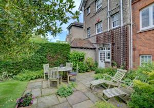 a patio with a table and chairs in front of a building at Garden Flat in Sandwich