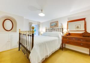 a bedroom with a bed and a dresser and a mirror at Garden Flat in Sandwich