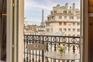 a balcony with a table and a view of the eiffel tower at Splendid Hôtel in Paris +65 photos