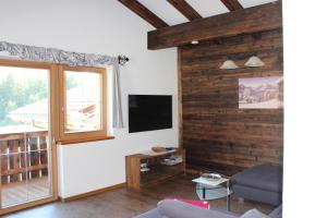 a living room with wooden walls and a flat screen tv at Ferienhaus Schwab in Mittersill