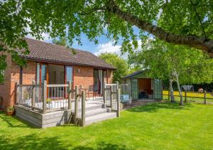 a brick house with a porch and a deck at Hexden Lea in Rolvenden