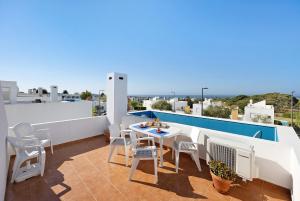 einen Balkon mit einem Tisch und Stühlen auf dem Dach in der Unterkunft Villa Roxana in Porches