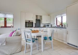 a kitchen with a table and chairs and a couch at Hexden Lea in Rolvenden