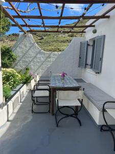 une table et des chaises assises sur une terrasse dans l'établissement Seaside Serenity, à Skiros