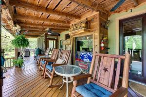 un porche con una fila de sillas y una mesa en Spacious Riverfront Cabin Near Local Attractions!, en Glenwood