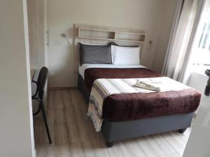 um quarto com uma cama grande e piso em madeira em 2 bedroomed apartment with en-suite and kitchenette - 2065 em Harare