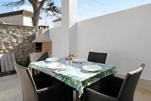 - une table avec des chaises et un chiffon de table sur la terrasse dans l'établissement Casa Josisa - Solo Familias, à Conil de la Frontera