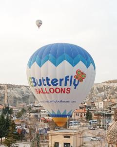 a hot air balloon flying over a city at Cappa Cave Hotel in Göreme