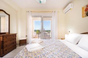 sypialnia z łóżkiem z komodą i oknem w obiekcie Wonderful Villa in Chania with Private Pool, Panoramic Sea Views & Spacious Interiors w mieście Agios Onoufrios