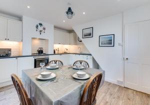 a kitchen and dining room with a table and chairs at Fishermans Cottage in Kingsdown