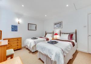 two beds in a room with white walls at Fishermans Cottage in Kingsdown