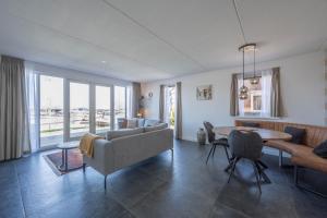a living room with a couch and a table at Meerzicht 24 - Luxury family accommodation with beautiful lake side view in Uitgeest