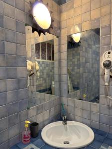ein Bad mit einem Waschbecken und einem Spiegel in der Unterkunft Hostel Museum in Koper